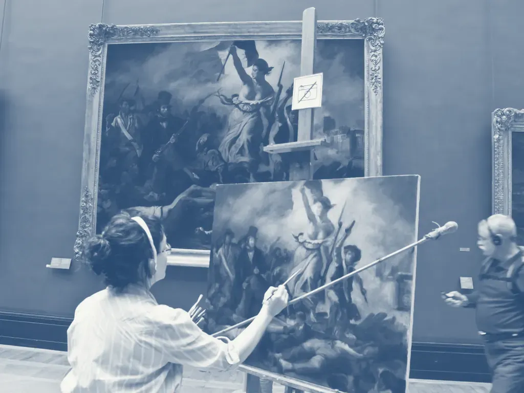 A painter working on a canvas in front of a larger painting in a museum.