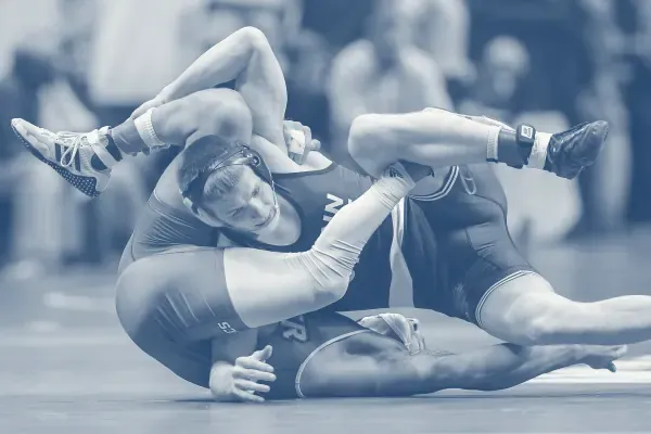 Two wrestlers locked in a struggle on a mat.
